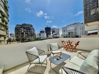 a balcony with chairs and a table on a building at CFC - Douceur et luminosité in Oulad Akkou