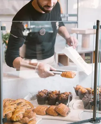a man is preparing food in a bakery at CFC - Douceur et luminosité in Oulad Akkou