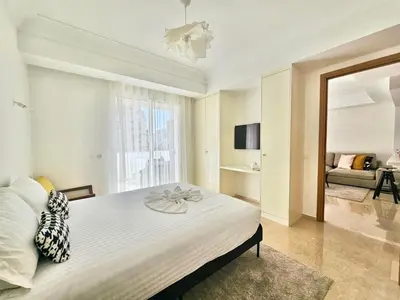a bedroom with a large bed and a living room at CFC - Douceur et luminosité in Oulad Akkou