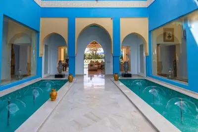 a swimming pool in a house with blue walls at Palais pyar in Najem