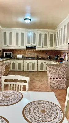 a kitchen with white cabinets and a table and chairs at Marrakech Villa Floor Private Garden & Sport Space in Oulad Akkou