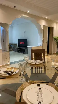 a dining room with a table with glasses and a television at Marrakech Villa Floor Private Garden & Sport Space in Oulad Akkou