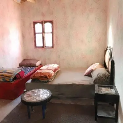 a bedroom with a large bed and a window at Café nour dar ait ben haddou in Taskoukte