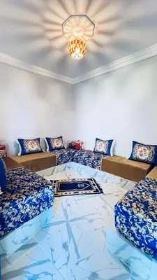 a room with two beds and a chandelier at Chez Mazgiti in Ourika