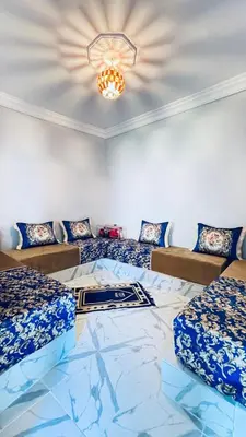 a room with two beds and a chandelier at Chez Mazgiti in Ourika