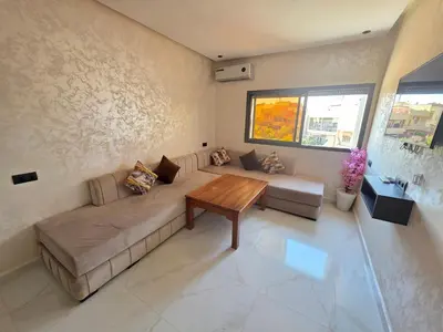 a living room with a couch and a table at Appartement luxe 3 in Khenifra