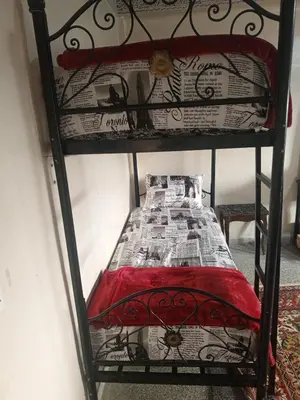 a black bunk bed with a red and white comforter at KASBAH Guests Travel in Fès