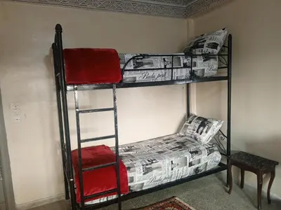 two bunk beds in a room with newspapers and a chair at KASBAH Guests Travel in Fès