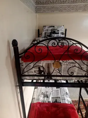 a bedroom with a bed with newspapers on it at KASBAH Guests Travel in Fès