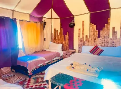 a room with two beds in a tent at Merzouga Toop Luxury Camp in Merzouga