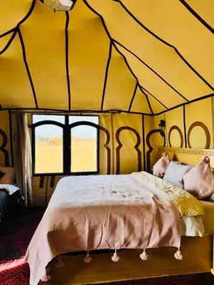 a bedroom with a bed in a tent at Merzouga Toop Luxury Camp in Merzouga