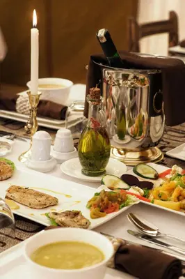 a table topped with plates of food and a candle at Merzouga Toop Luxury Camp in Merzouga
