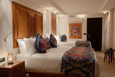 a bedroom with a large bed with blue pillows at Riad Joy in Fès