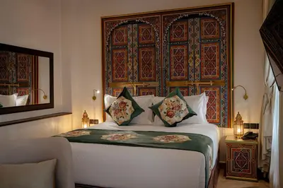 a bedroom with a bed with a large headboard at Riad Joy in Fès