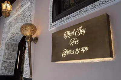 a sign on a wall next to a lamp at Riad Joy in Fès