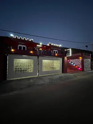 a building with lights on the side of it at night at Auberge Touristique Toubkal in Imlil