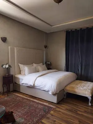 a bedroom with a large white bed and a table at dar Jellouna Zaraba in Oulad Akkou