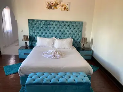 a bedroom with a large bed with a blue headboard at dar Jellouna Zaraba in Oulad Akkou