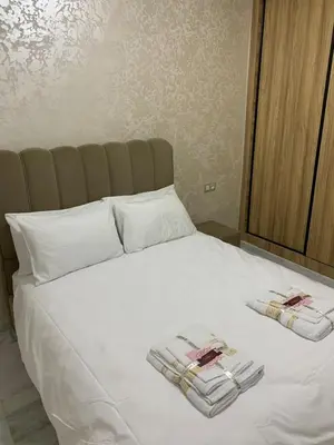 a white bed with two piles of towels on it at Luxueux - Vue sublime - Fes City Center - à 2 min du parc de champs de course in Fès