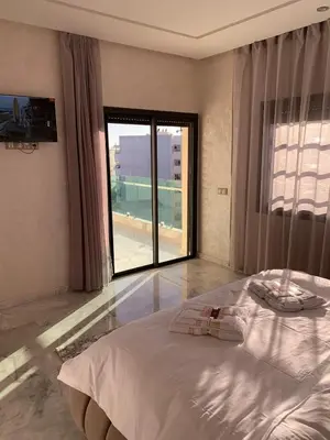 a bedroom with a large bed and a large window at Luxueux - Vue sublime - Fes City Center - à 2 min du parc de champs de course in Fès