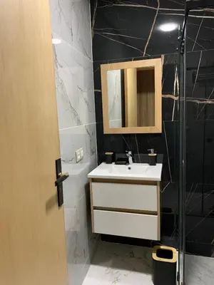 a bathroom with a sink and a mirror and a shower at Luxueux - Vue sublime - Fes City Center - à 2 min du parc de champs de course in Fès