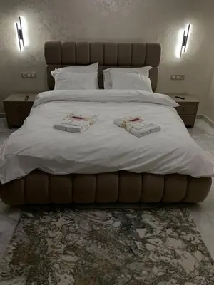 a large bed with white sheets and pillows on it at Luxueux - Vue sublime - Fes City Center - à 2 min du parc de champs de course in Fès