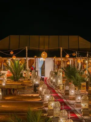 a row of lights on a table with chairs at Honeymoon Luxury Camp in Merzouga
