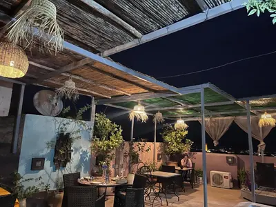 a patio with tables and chairs and lights at dar annee in Fès