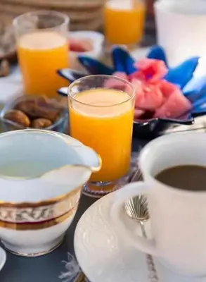 a table with a cup of coffee and a plate of food at dar annee in Fès