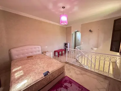 a bedroom with a large bed and a pink light at oasis des collines