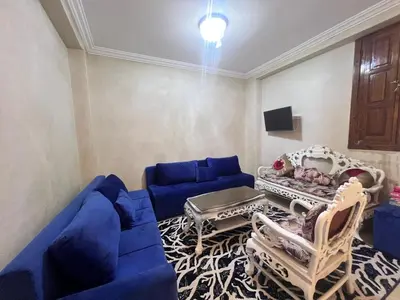 a living room with a blue couch and chairs at oasis des collines