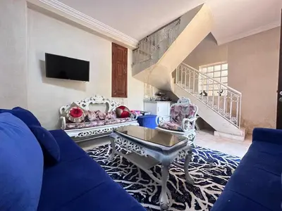 a living room with a blue couch and a staircase at oasis des collines