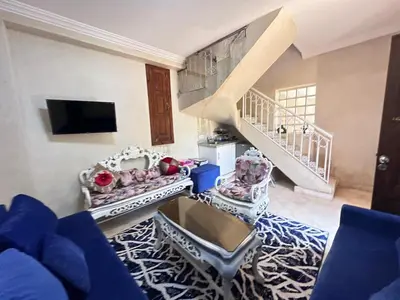 a living room with a blue couch and a staircase at oasis des collines