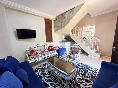 a living room with a blue couch and a staircase at oasis des collines