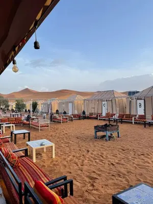 a group of tables and benches in the desert at Sindibad Desert Camp in Merzouga