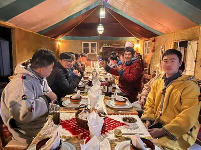a group of people sitting around a long table at Sindibad Desert Camp in Merzouga