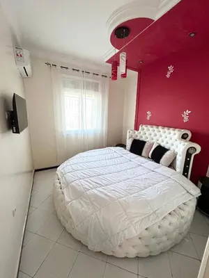a bedroom with a white bed with a red wall at Grand appartement familial - Calme & bien situé à Mèknes in Meknès