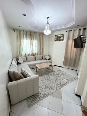 a living room with a couch and a table at Grand appartement familial - Calme & bien situé à Mèknes in Meknès