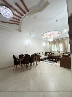 a living room with a table and chairs and a couch at Grand appartement familial - Calme & bien situé à Mèknes in Meknès