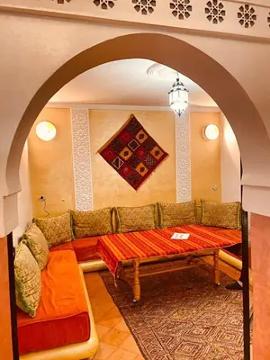 a living room with a couch and a table at Merzouga Hous in Merzouga
