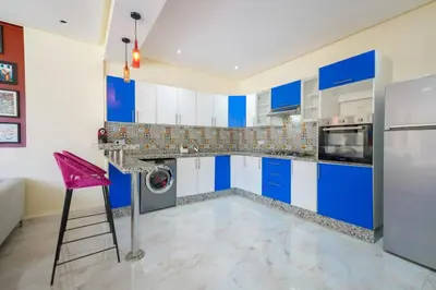 a kitchen with blue and white cabinets and a pink stool at Villa de Luxe à Marrakech avec Piscine Chauffée Privée in Aghmat