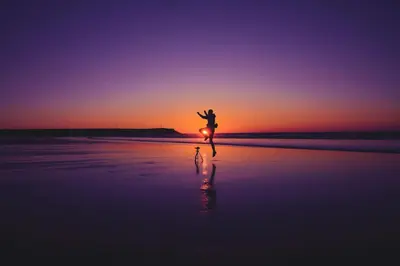 a person dancing on the beach at sunset at FAVori in Oulad Akkou