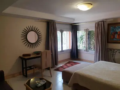 a bedroom with a bed and a desk and a mirror at Villa palmeraie Marrakech in Najem