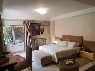 a bedroom with a bed and a table and a couch at Villa palmeraie Marrakech in Najem