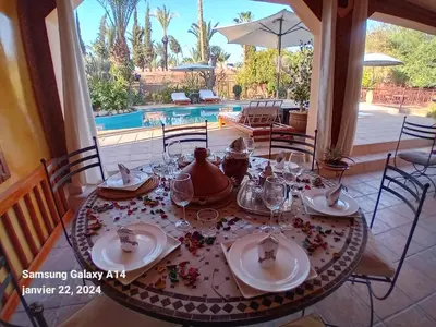 a dining room table with plates and glasses on it at Villa palmeraie Marrakech in Najem