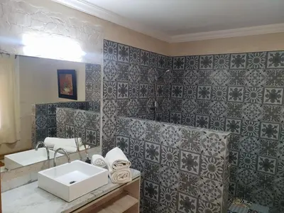 a bathroom with a sink and a tile wall at Villa palmeraie Marrakech in Najem