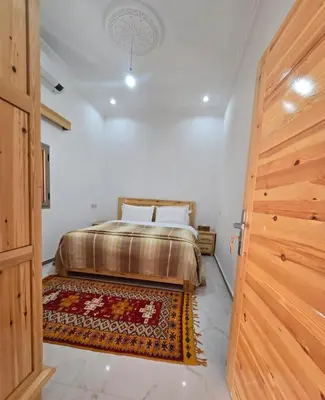 a bedroom with a bed and a rug on the floor at Riad Gogo in Aït Ben Haddou