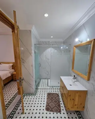 a bathroom with a shower and a sink and a mirror at Riad Gogo in Aït Ben Haddou