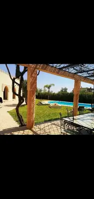 a pavilion with a picnic table and a swimming pool at Villa athis in Fourou