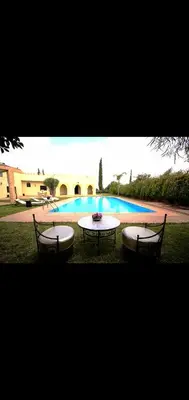 two chairs and a table in front of a pool at Villa athis in Fourou